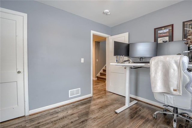 office area with baseboards, visible vents, and wood finished floors