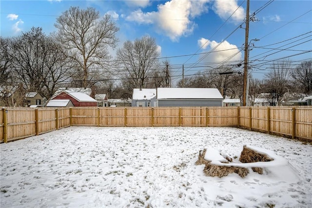 yard layered in snow with a fenced backyard