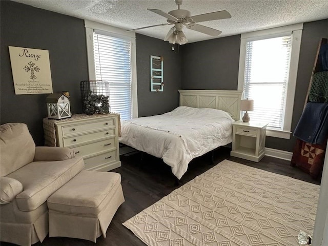 bedroom with ceiling fan, hardwood / wood-style flooring, and a textured ceiling