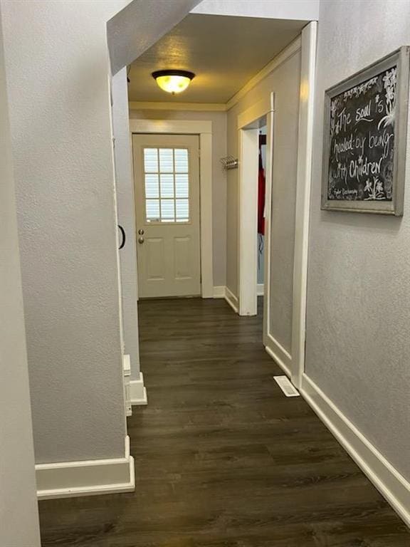 doorway to outside featuring dark wood-type flooring and ornamental molding