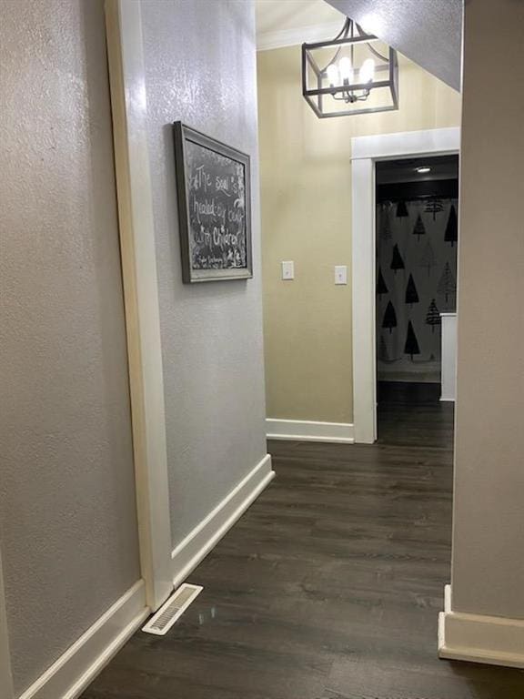 hall featuring an inviting chandelier and dark wood-type flooring