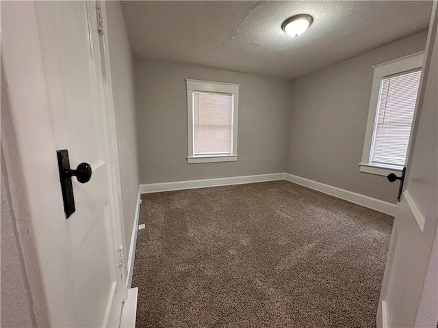 unfurnished room with plenty of natural light, carpet, and a textured ceiling