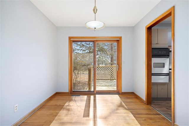 doorway to outside with light wood-style flooring and baseboards