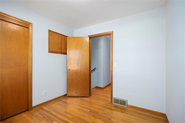 unfurnished bedroom with light wood-style flooring, visible vents, and baseboards