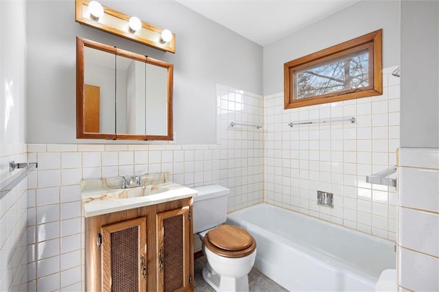 full bath featuring toilet, wainscoting, tile walls, and vanity