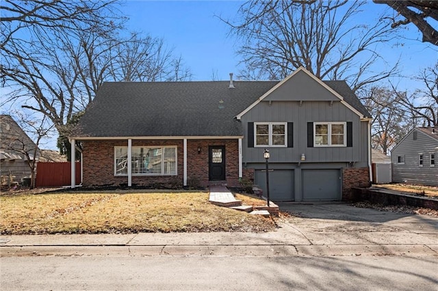 split level home featuring an attached garage, driveway, fence, and brick siding