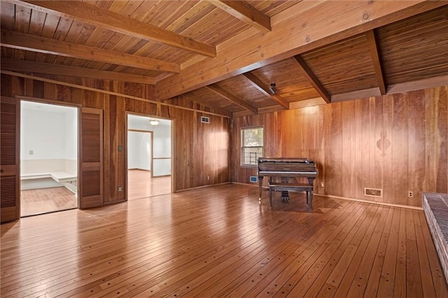 misc room featuring wooden ceiling, wood walls, lofted ceiling with beams, and hardwood / wood-style floors