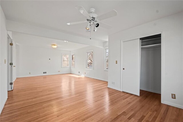 unfurnished bedroom featuring light wood finished floors, visible vents, baseboards, and a closet