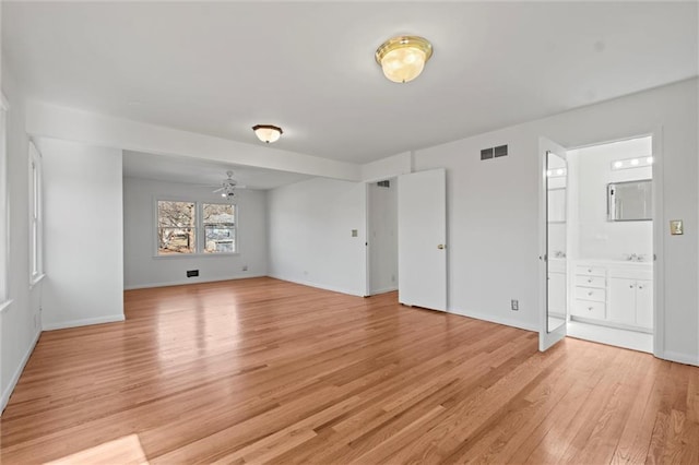 spare room with light wood-style floors, baseboards, and visible vents