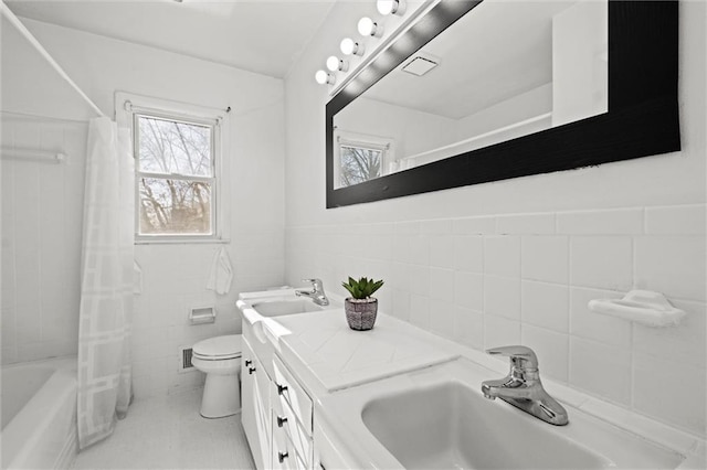 full bathroom with a wealth of natural light, a sink, tile walls, and toilet