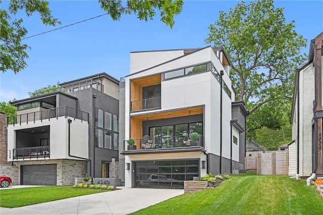 contemporary house with concrete driveway, a garage, a front yard, and stucco siding