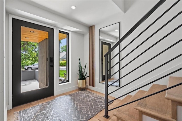 entryway featuring recessed lighting, baseboards, wood finished floors, and stairs