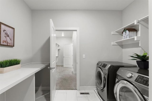 washroom featuring baseboards, laundry area, and washer and dryer