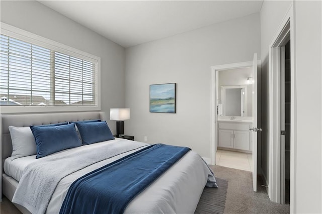 carpeted bedroom featuring baseboards and connected bathroom