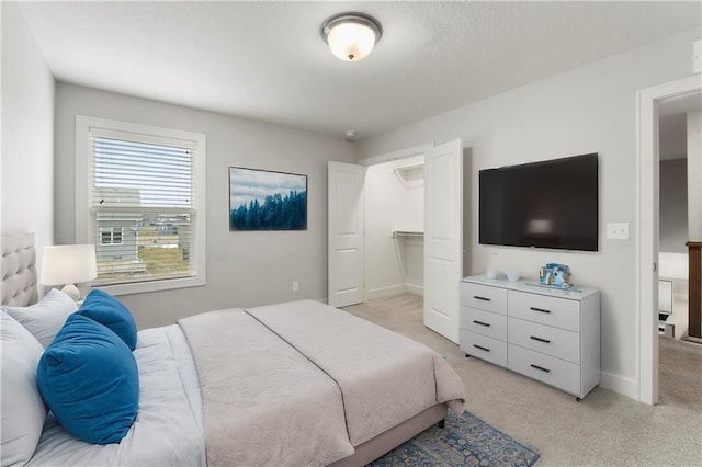 bedroom featuring baseboards and light colored carpet