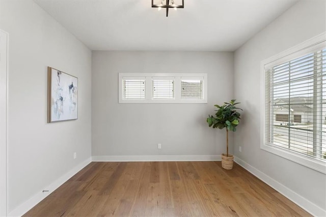 unfurnished room featuring wood finished floors and baseboards