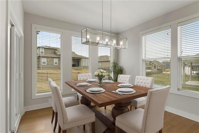 dining area with healthy amount of natural light, a chandelier, and baseboards