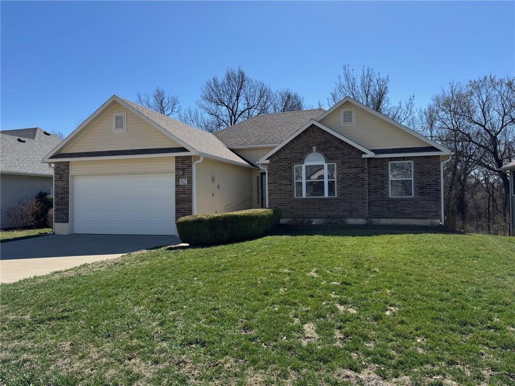 512 Wildwood Ct, Warrensburg, MO 64093 - single story home featuring brick siding, a front yard, and a garage