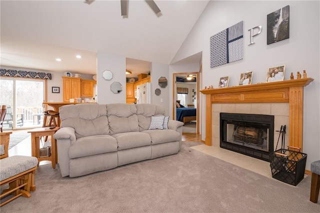 living room with a fireplace, high vaulted ceiling, light colored carpet, and ceiling fan