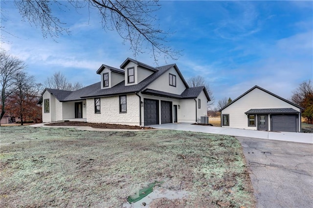 view of front facade with driveway, central AC unit, and an attached garage