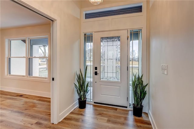 foyer with light wood-type flooring and baseboards