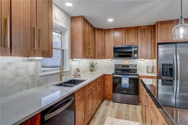 kitchen with light wood finished floors, a sink, stainless steel range with electric stovetop, black microwave, and dishwasher