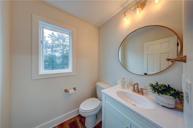 bathroom featuring wood finished floors, vanity, toilet, and baseboards