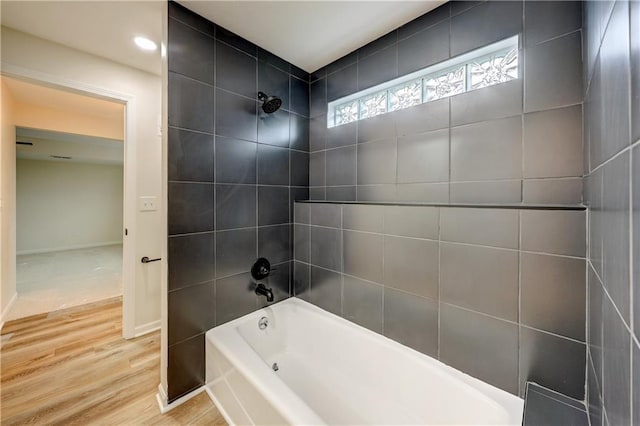 bathroom with baseboards, shower / tub combination, and wood finished floors