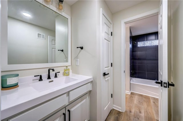 bathroom featuring vanity, shower / bath combination, wood finished floors, and visible vents