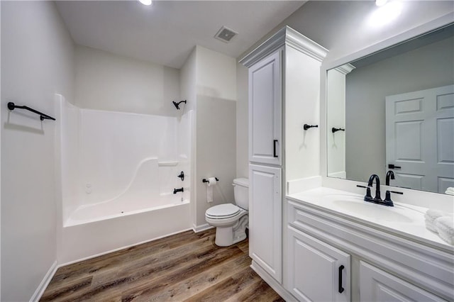 bathroom featuring visible vents, toilet, shower / tub combination, wood finished floors, and vanity