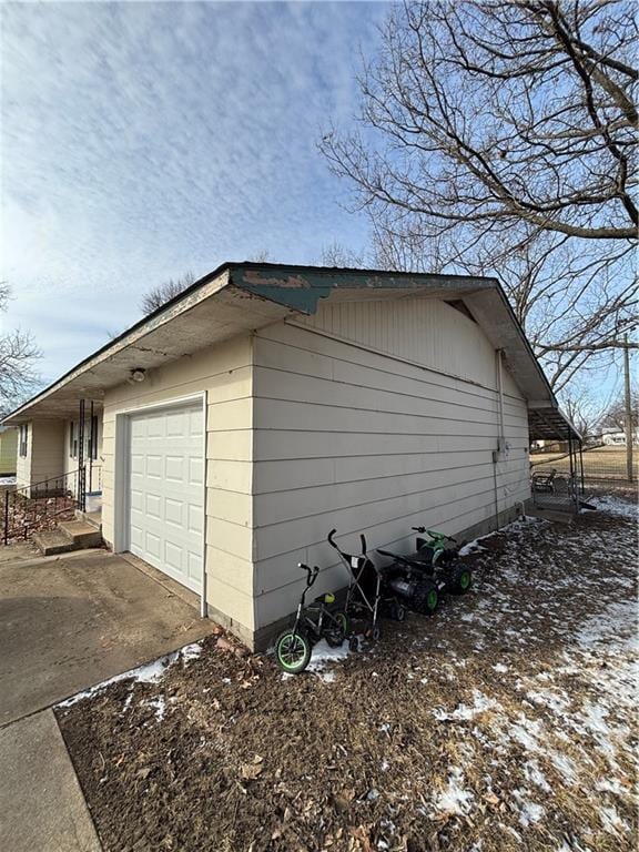 view of snowy exterior featuring a garage