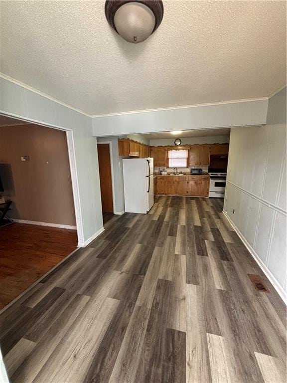 unfurnished living room featuring crown molding, dark hardwood / wood-style floors, and a textured ceiling