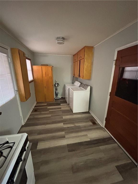 washroom featuring dark wood-type flooring, crown molding, and separate washer and dryer