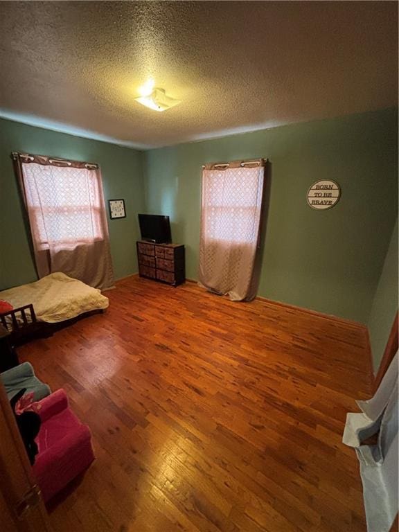 bedroom featuring hardwood / wood-style floors and a textured ceiling