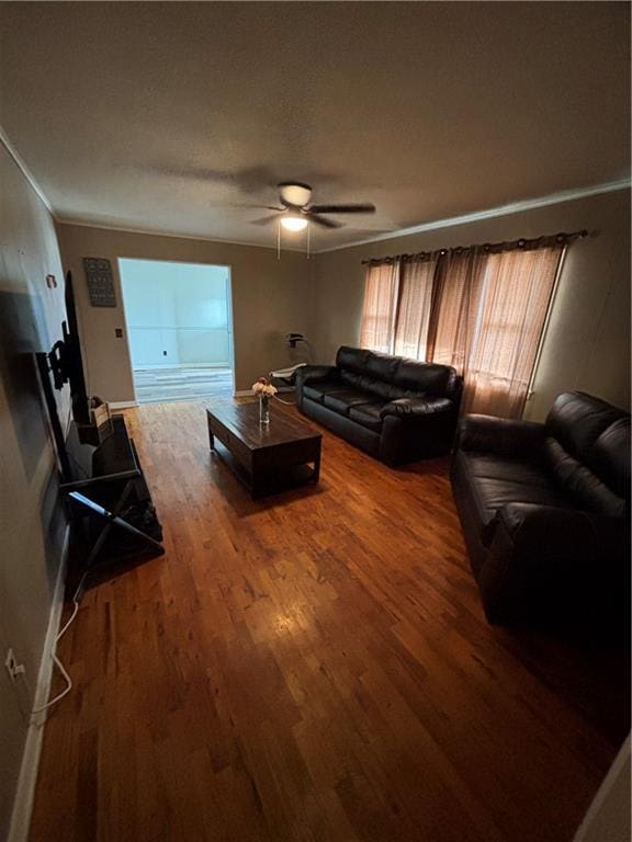 living room featuring hardwood / wood-style flooring, ceiling fan, and crown molding