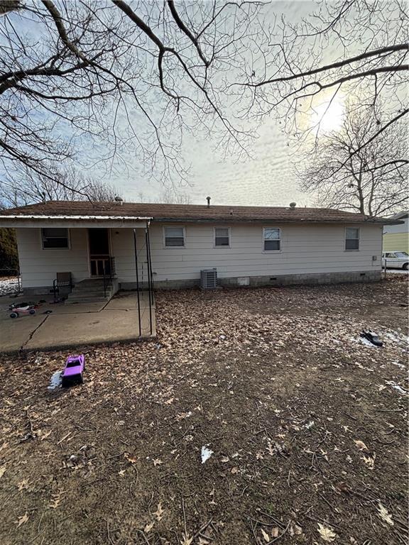 back of property with central AC unit and a patio area