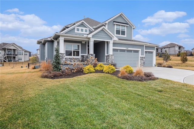 view of front facade featuring a front yard, stone siding, driveway, and an attached garage