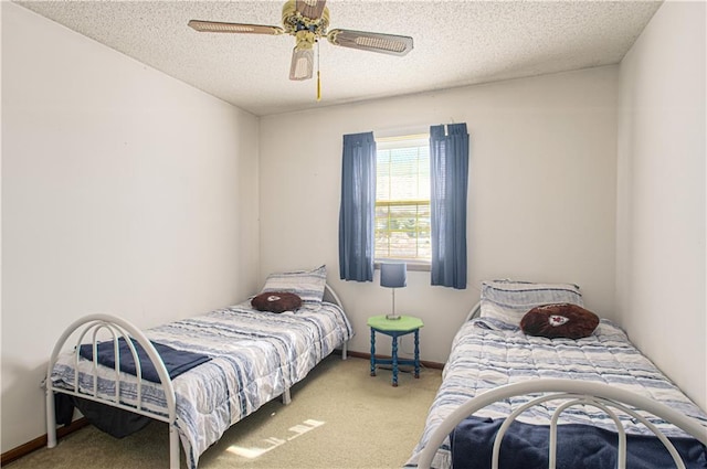 carpeted bedroom with ceiling fan, baseboards, and a textured ceiling