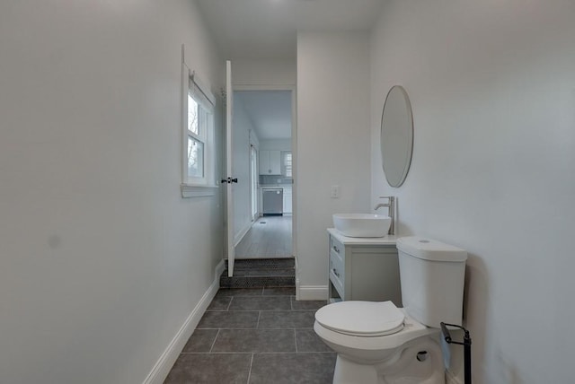 bathroom featuring tile patterned flooring, baseboards, vanity, and toilet