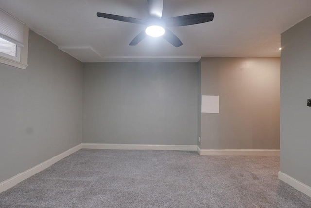 carpeted empty room with a ceiling fan and baseboards