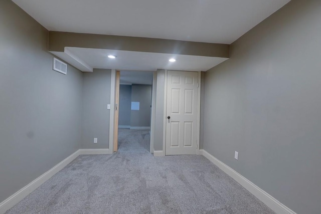 finished below grade area featuring light carpet, recessed lighting, visible vents, and baseboards