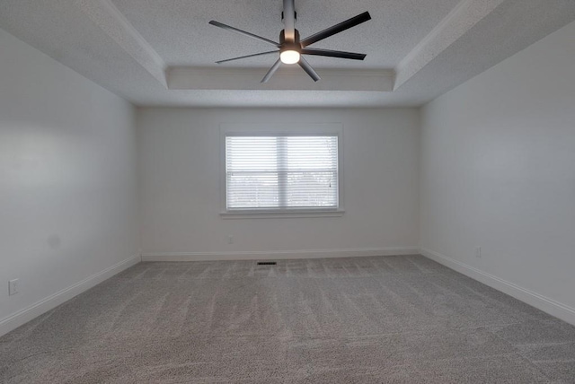 carpeted spare room with baseboards, a tray ceiling, ceiling fan, and a textured ceiling