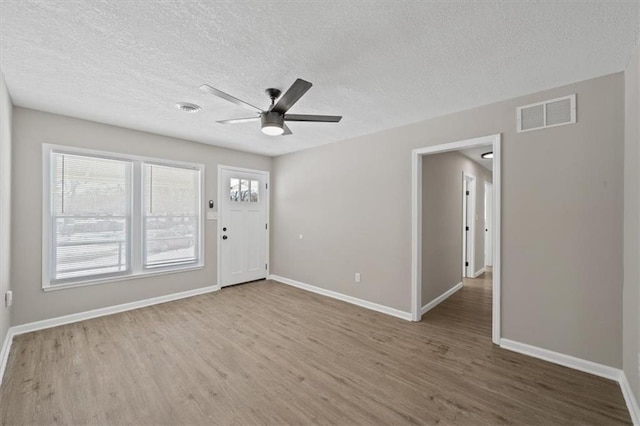 unfurnished room featuring hardwood / wood-style floors, a textured ceiling, and ceiling fan