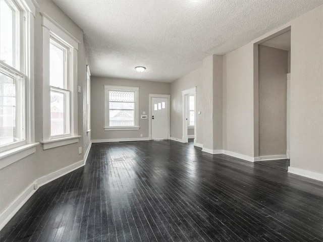 unfurnished living room with dark hardwood / wood-style floors and a textured ceiling