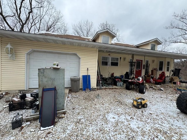 view of snowy exterior with a garage and a porch