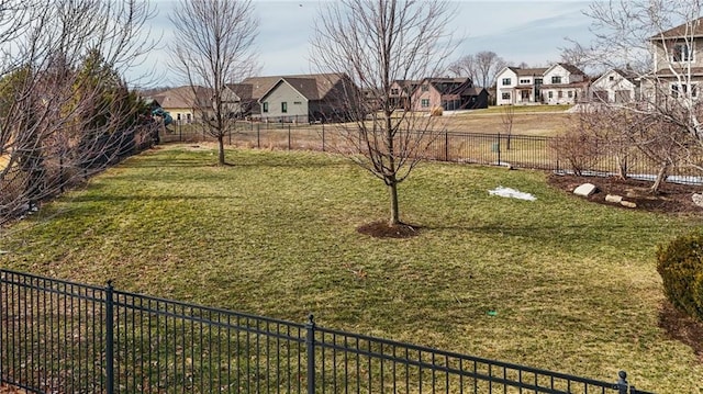 view of yard featuring fence and a residential view