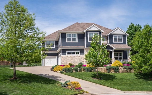 view of front of property with a garage, stone siding, a front yard, and concrete driveway