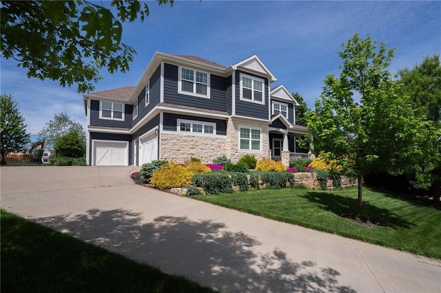 view of front of property featuring a garage, driveway, a front lawn, and stone siding