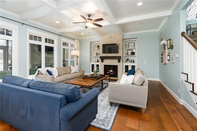 living area with a ceiling fan, ornamental molding, a wealth of natural light, and a fireplace