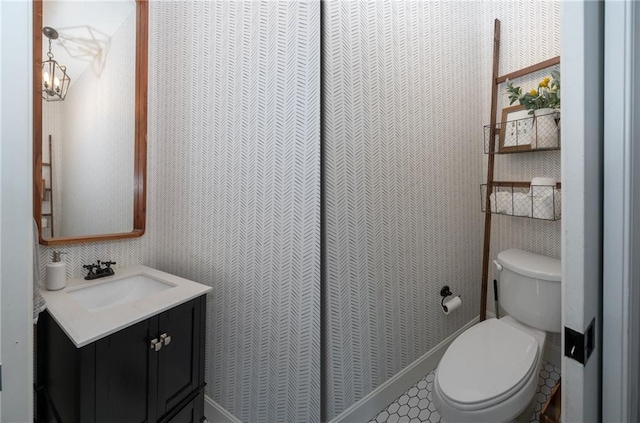 half bath featuring vanity and toilet